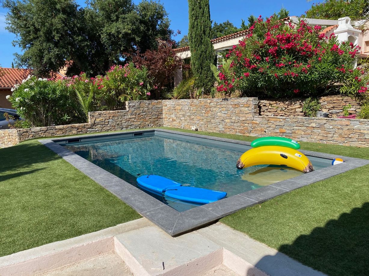 Une piscine entourée d'un muret en pierres