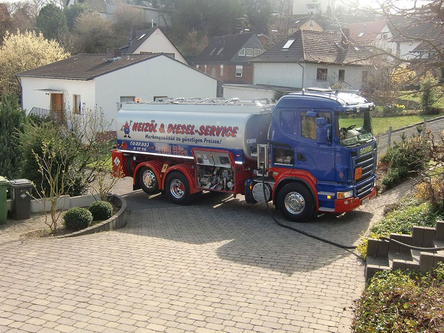 Ein blau-roter Tanklastwagen steht in einer Einfahrt