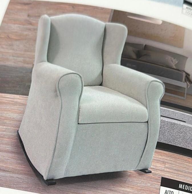 Una mecedora blanca está sobre un suelo de madera.