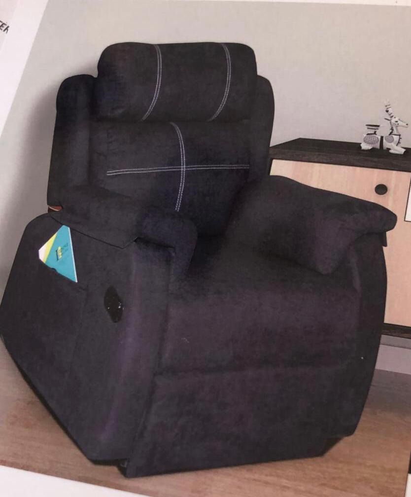 Un sillón reclinable negro con un bolsillo en el reposabrazos.