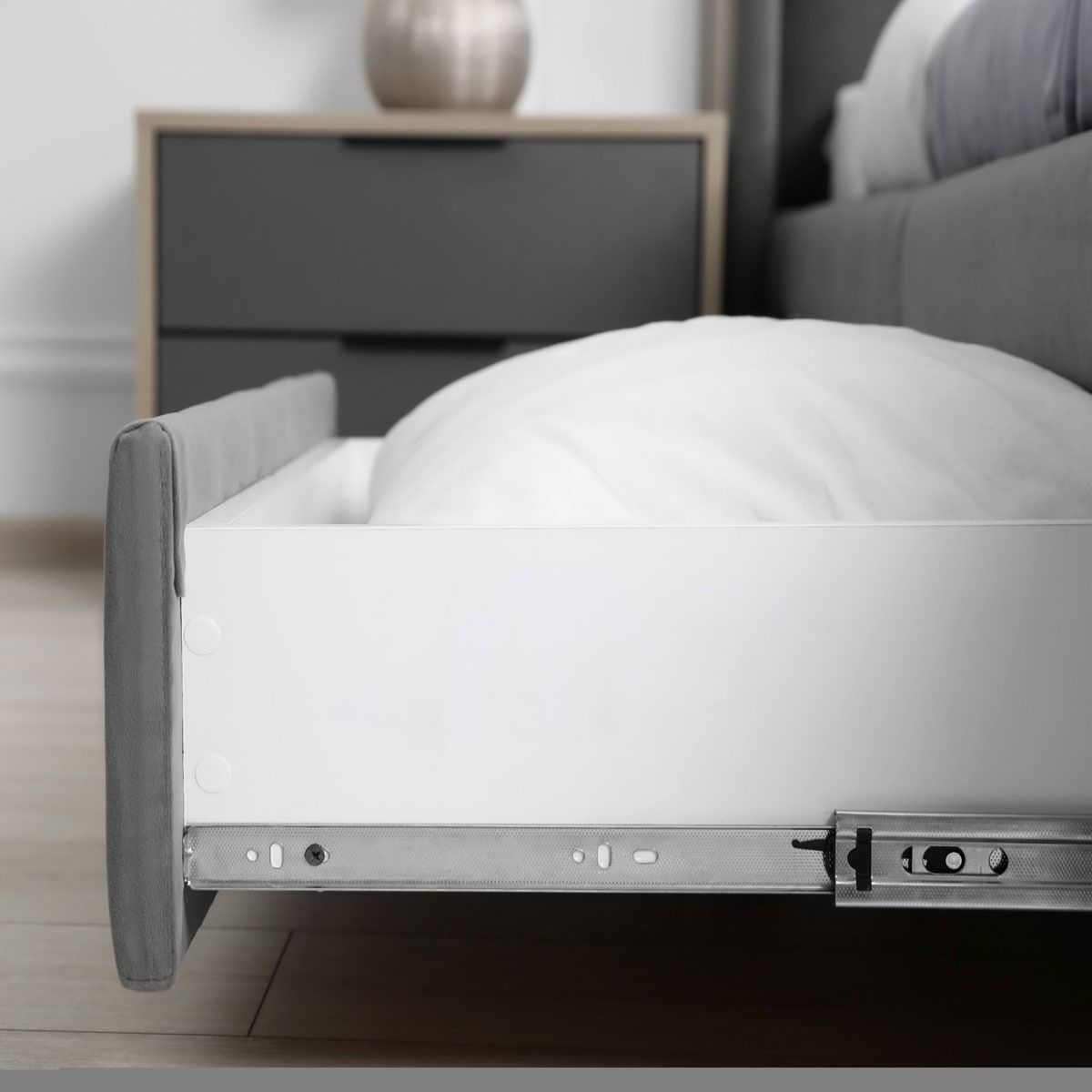 Un cajón blanco con una almohada dentro en un dormitorio.