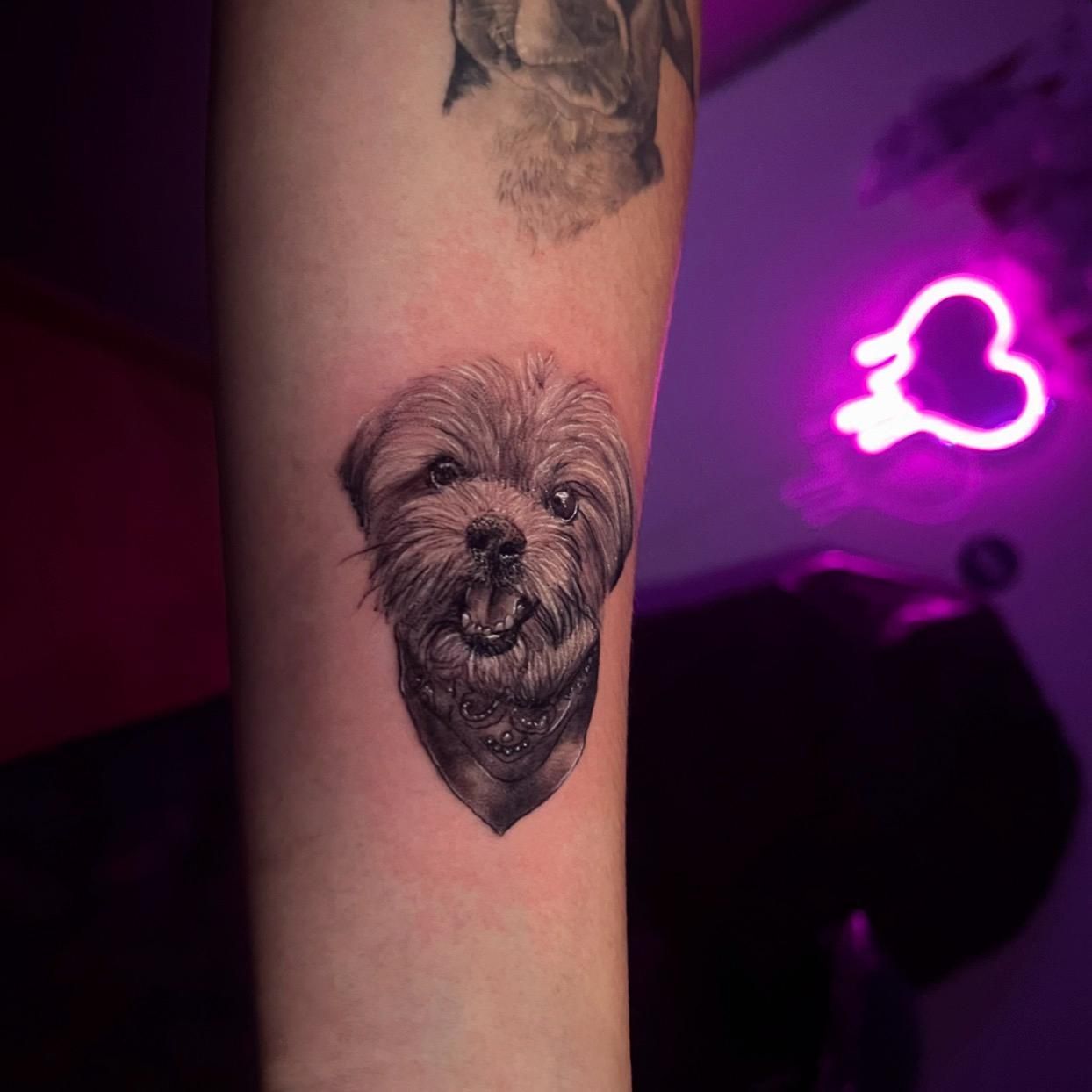 Una persona tiene un tatuaje de un perro en su antebrazo.