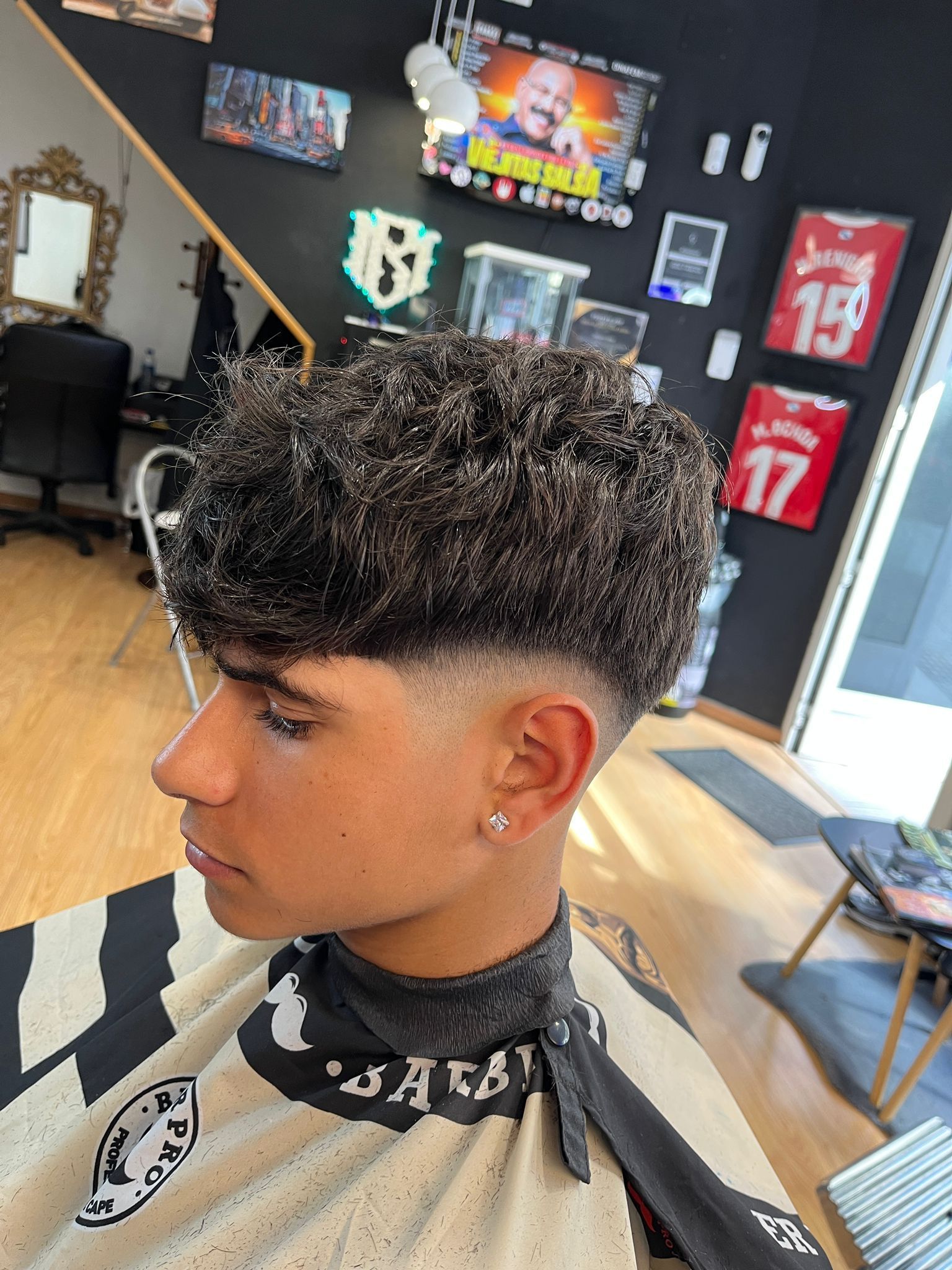 Un joven se está cortando el pelo en una barbería.