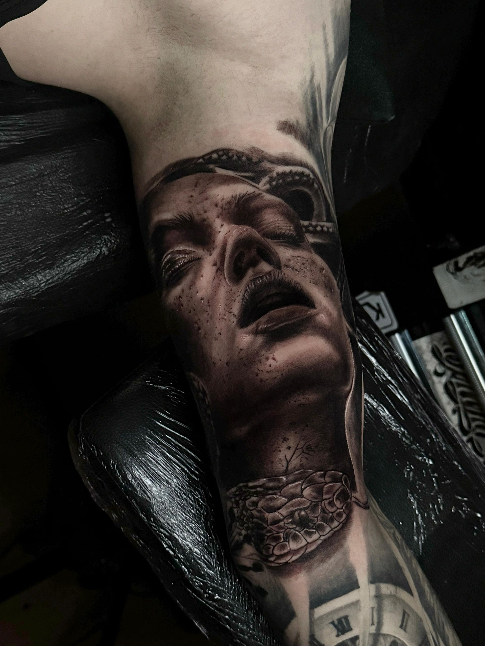 Una persona tiene un tatuaje de la cara de una mujer en su brazo.