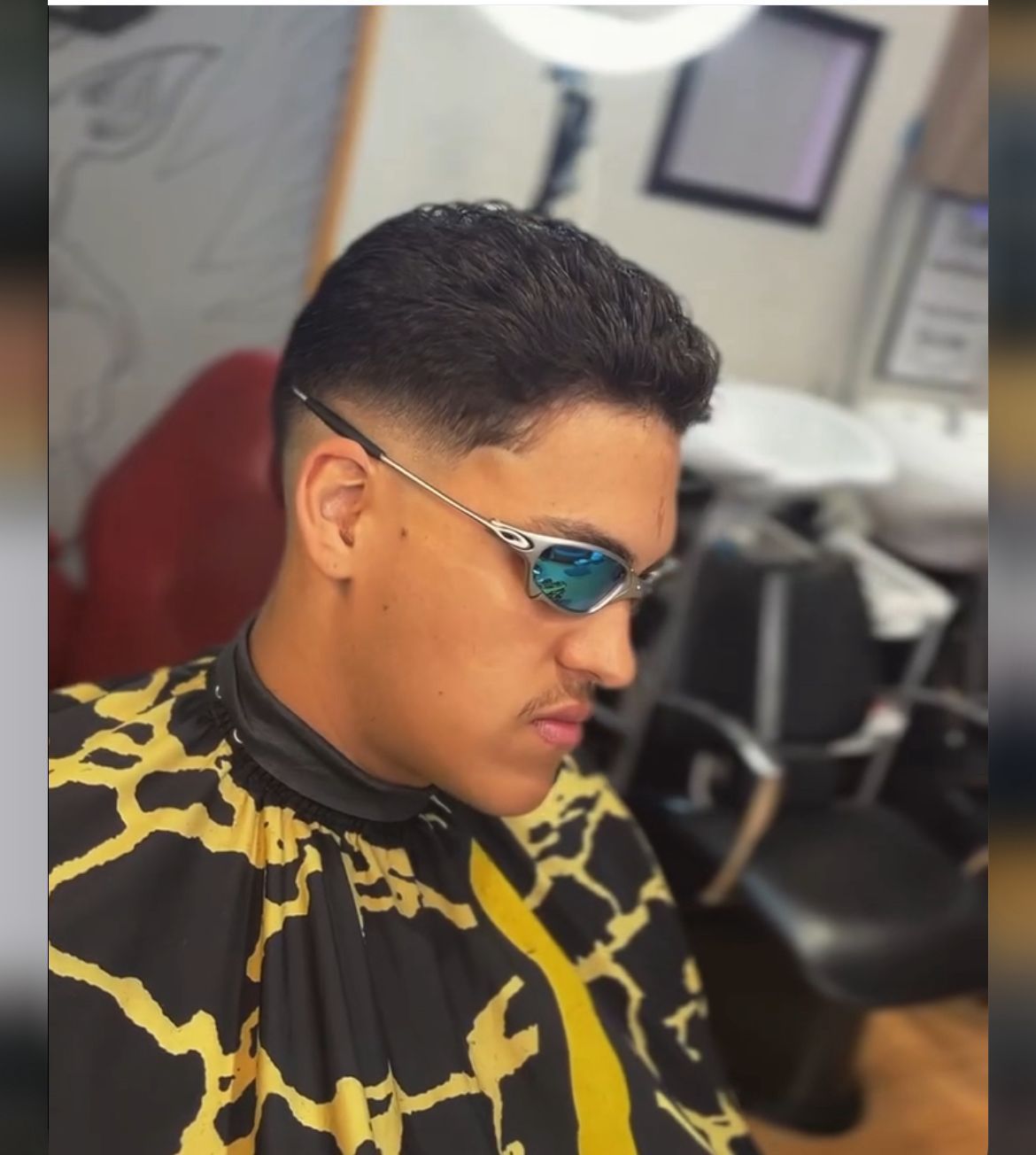 Un hombre que lleva gafas de sol y una camisa negra y amarilla.