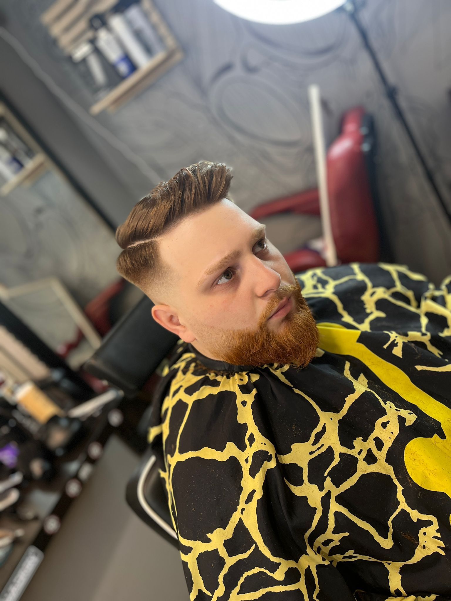 Un hombre con barba se está cortando el pelo en una barbería.