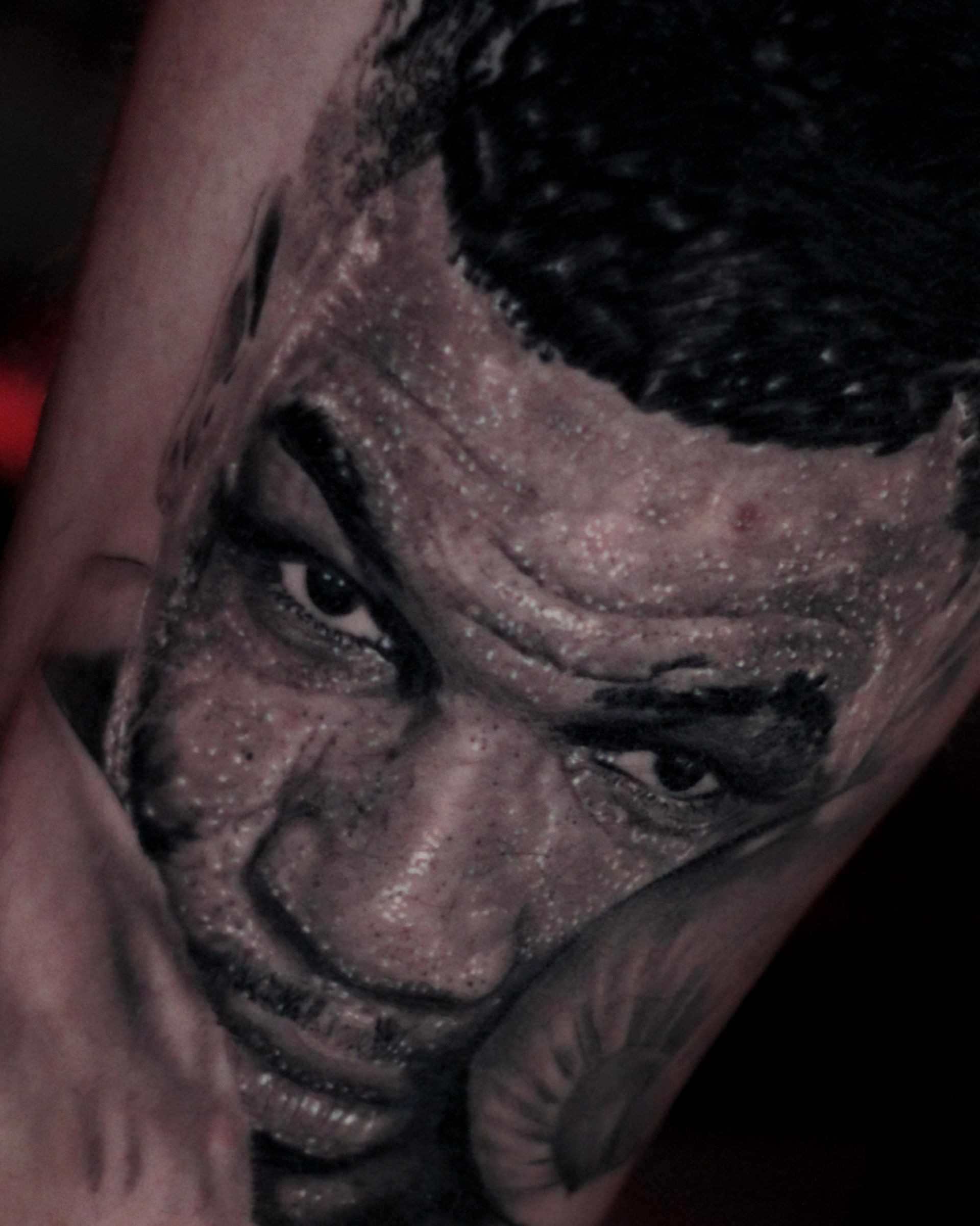 Un primer plano de un tatuaje de la cara de un hombre.