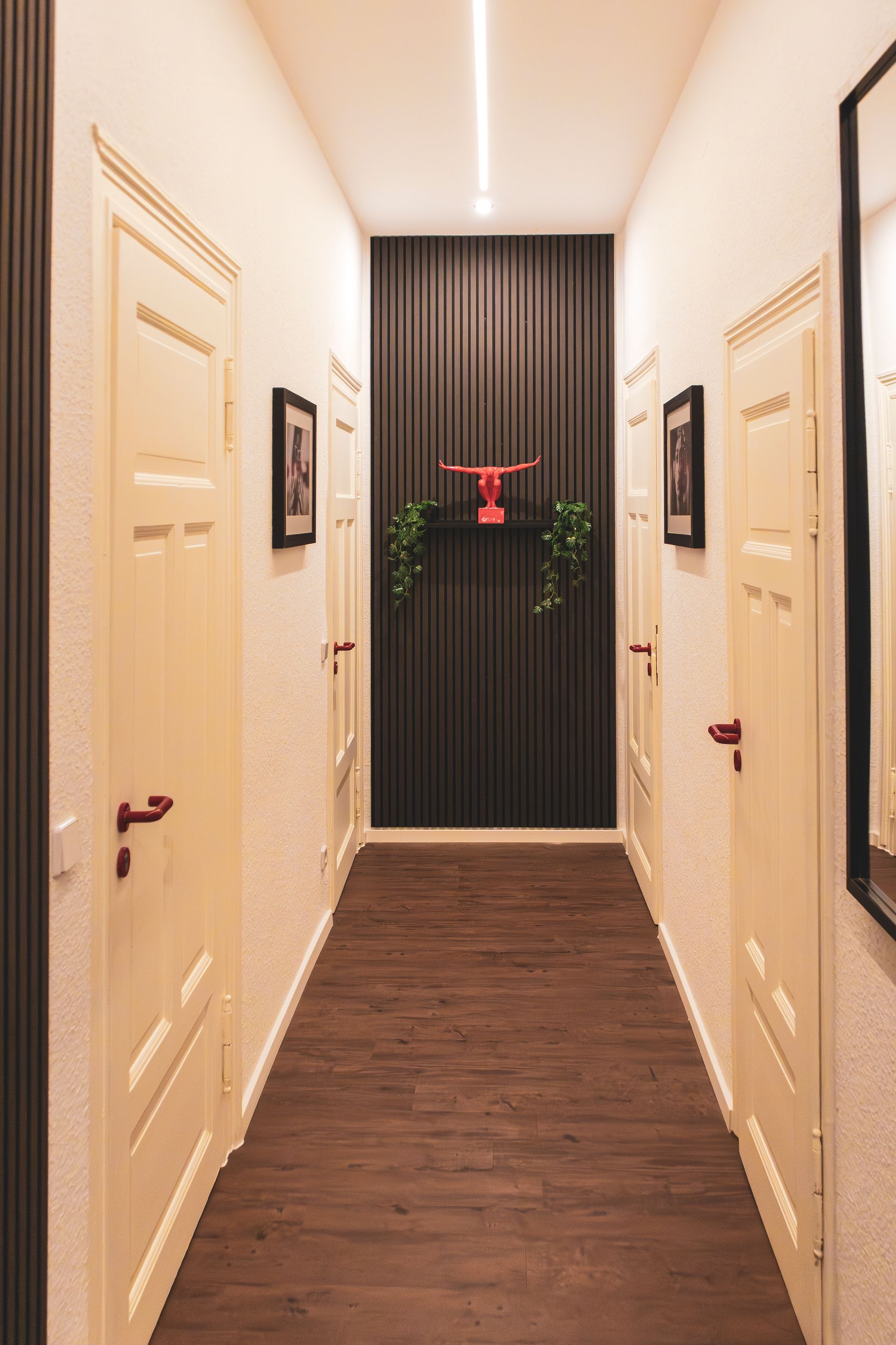 Helles Hotelzimmer mit Doppelbett, Vorhängen und gerahmter Fotokunst über dem Bett.