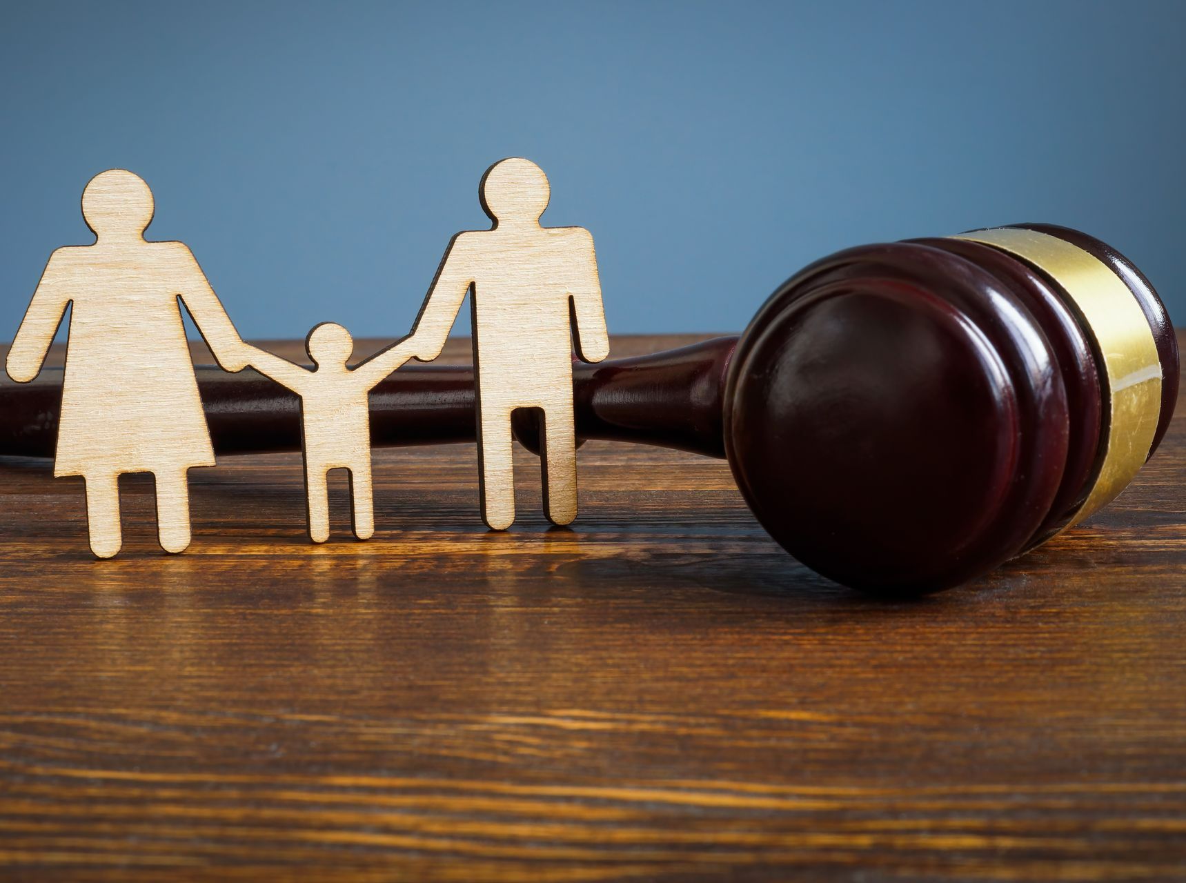 Des silhouettes en bois proches d'un maillet de justice