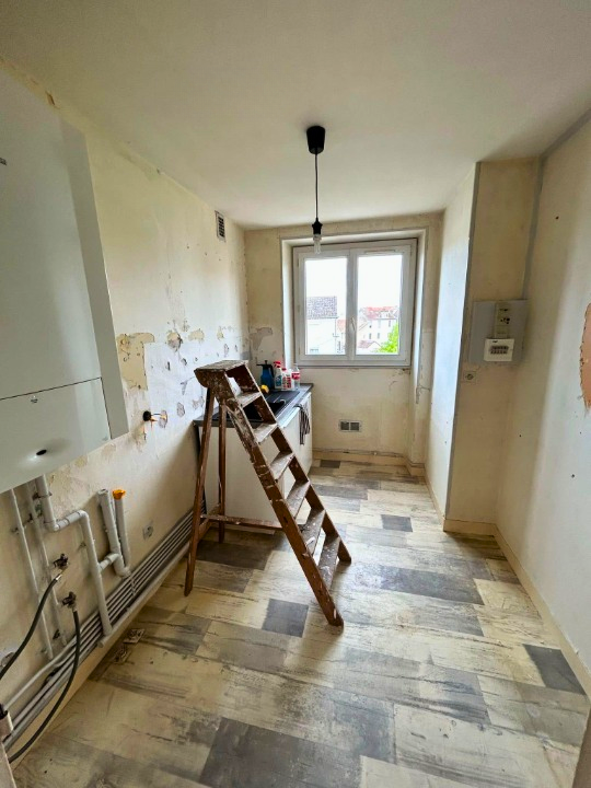 Pièce de cuisine en travaux avec un meuble à évier et une fenêtre