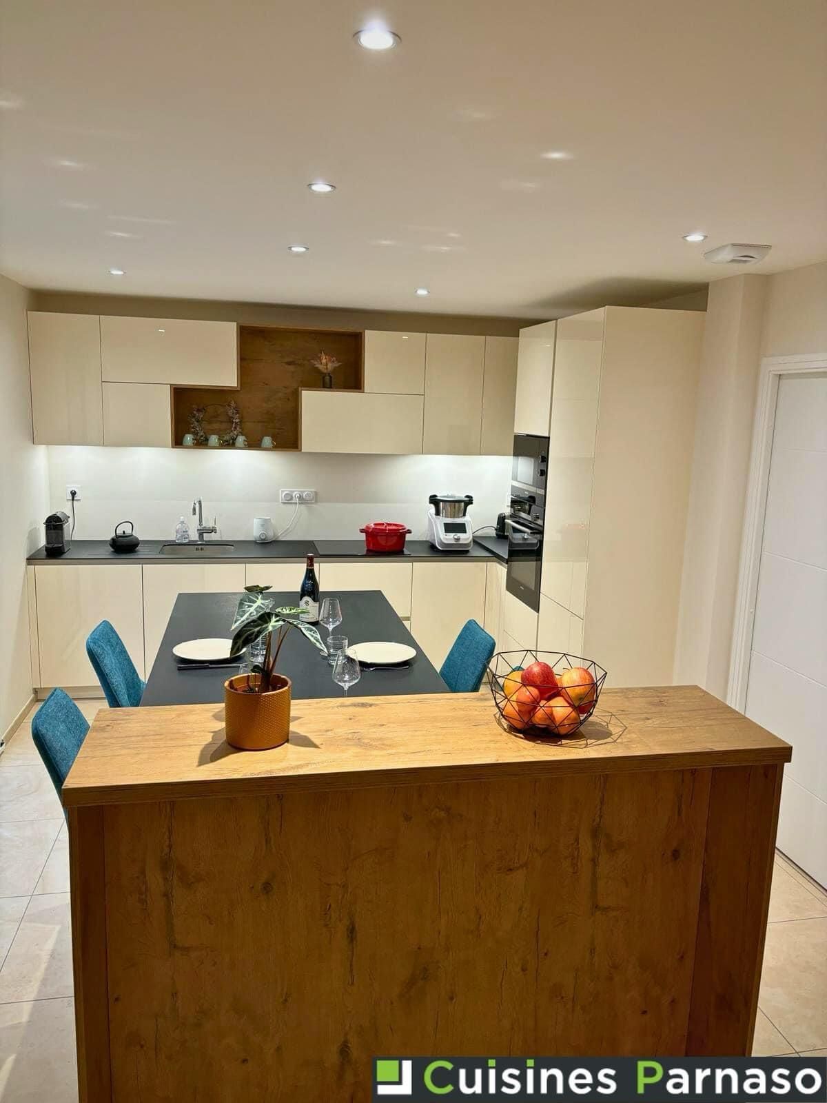 Cuisine équipée ouverte avec bar et niche coloris magnolia  et plan de travail compact noir roche