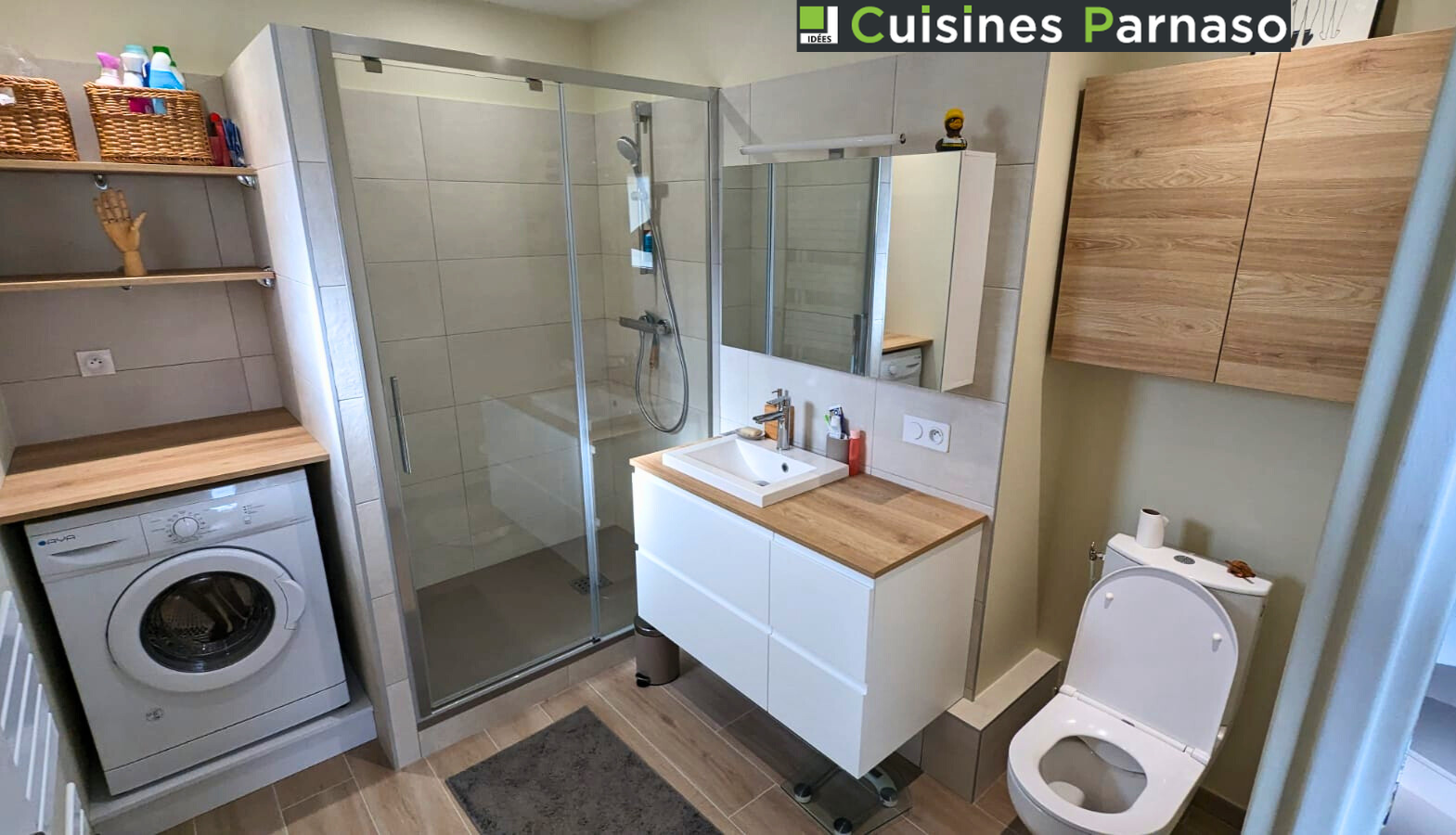 Salle de bains rénovée avec douche, lavabo et machine à laver