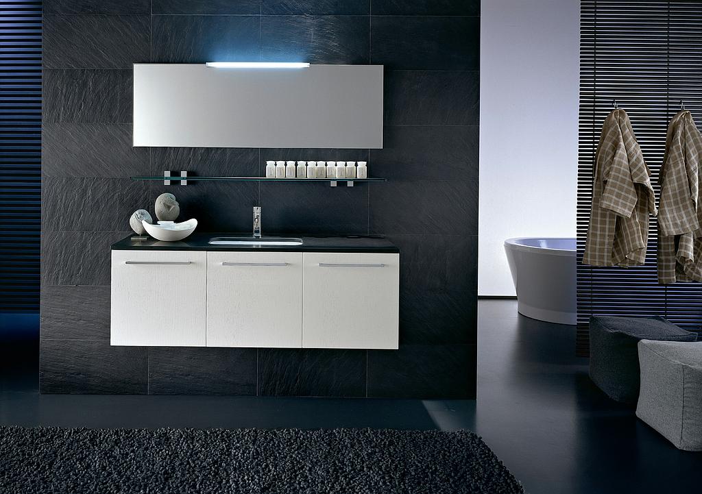 Salle de bains noire avec un meuble blanc et une baignoire au fond