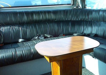 Un sofá de cuero negro con una mesa de madera delante.