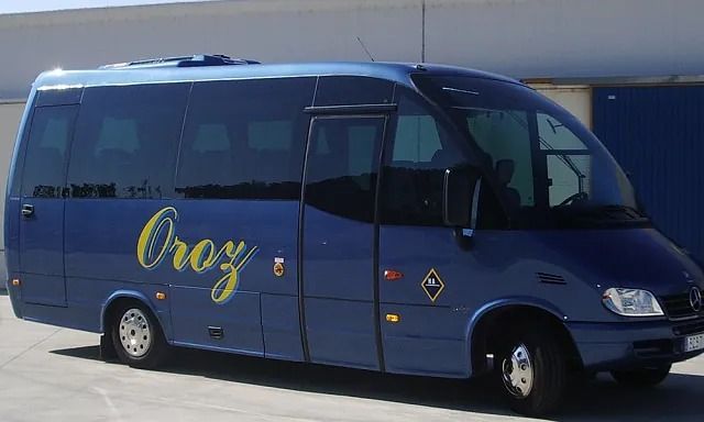 Un autobús azul con la palabra Oroy en el costado