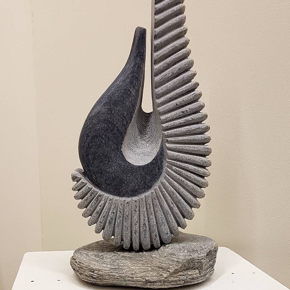 Une sculpture d'un oiseau est assise sur une table blanche