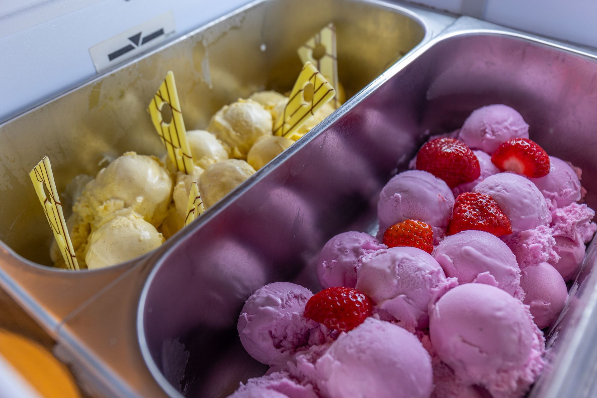 Es gibt zwei Behälter Eis mit Erdbeeren darin.