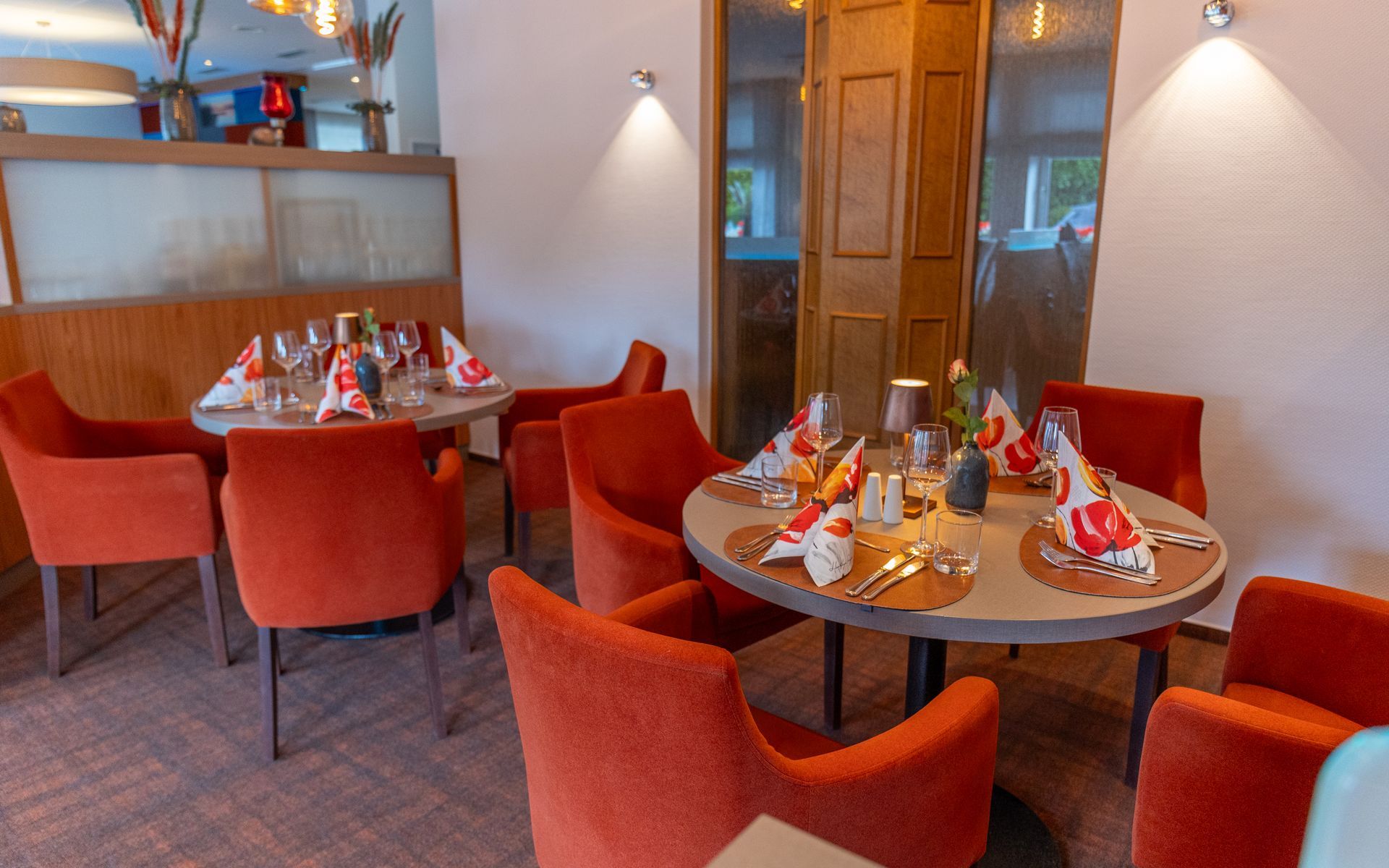 Ein Restaurant mit roten Stühlen und für eine Mahlzeit gedeckten Tischen.