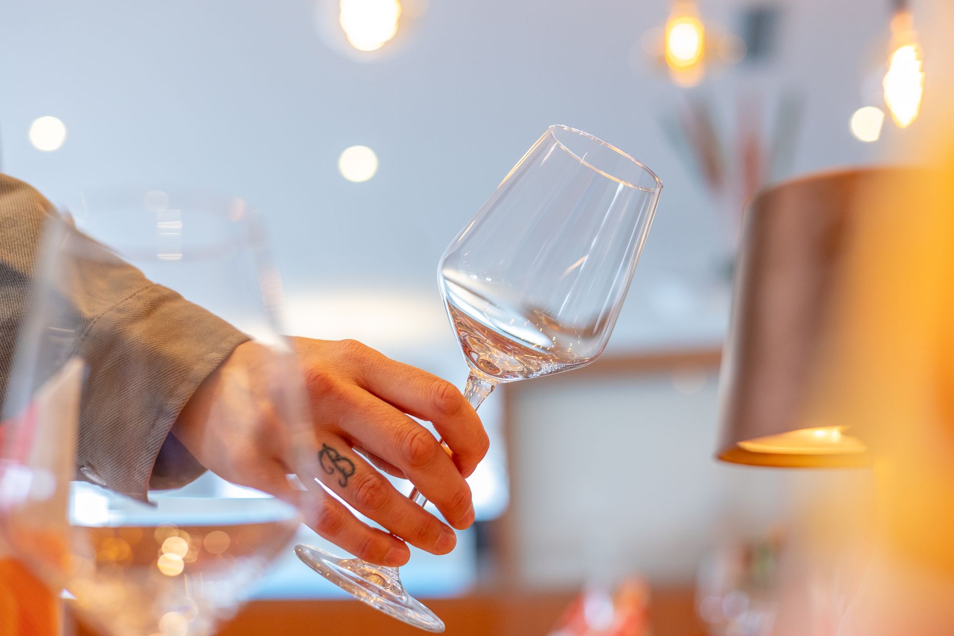 Eine Person hält ein leeres Weinglas in der Hand.