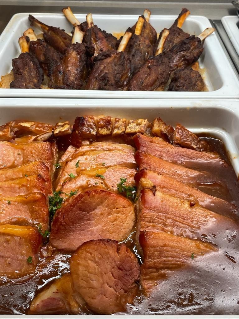 Zwei Tabletts mit Fleisch stehen nebeneinander auf einem Tisch.