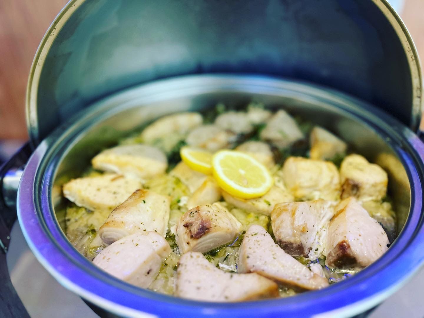 Eine Nahaufnahme eines Topfes mit Essen, darauf liegen Zitronenscheiben.