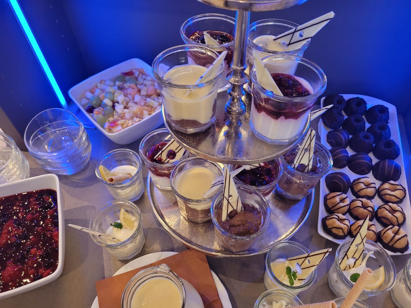 Ein Buffet-Tisch mit einem Turm aus Desserts darauf.