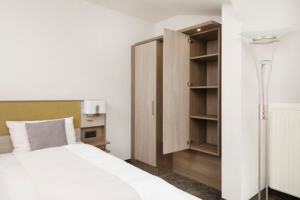 Ein Schlafzimmer mit einem Bett und einer Lampe und einem Kleiderschrank