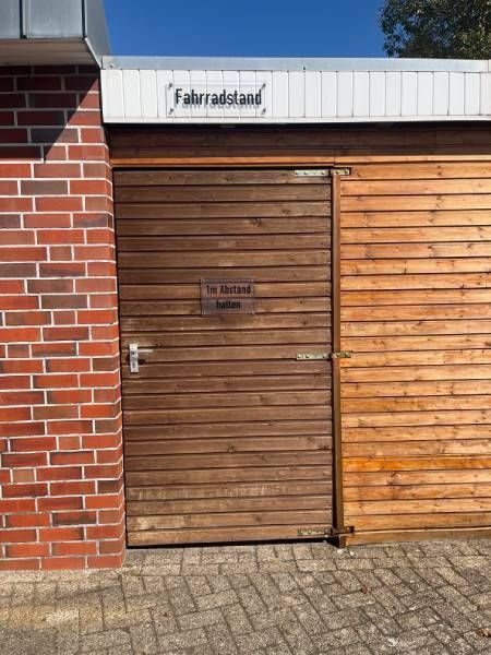 Ein Backsteingebäude mit einer Holztür und einem Schild mit der Aufschrift „Fahrradland“