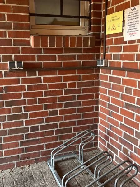 Eine Ziegelmauer mit einem Fahrradständer davor