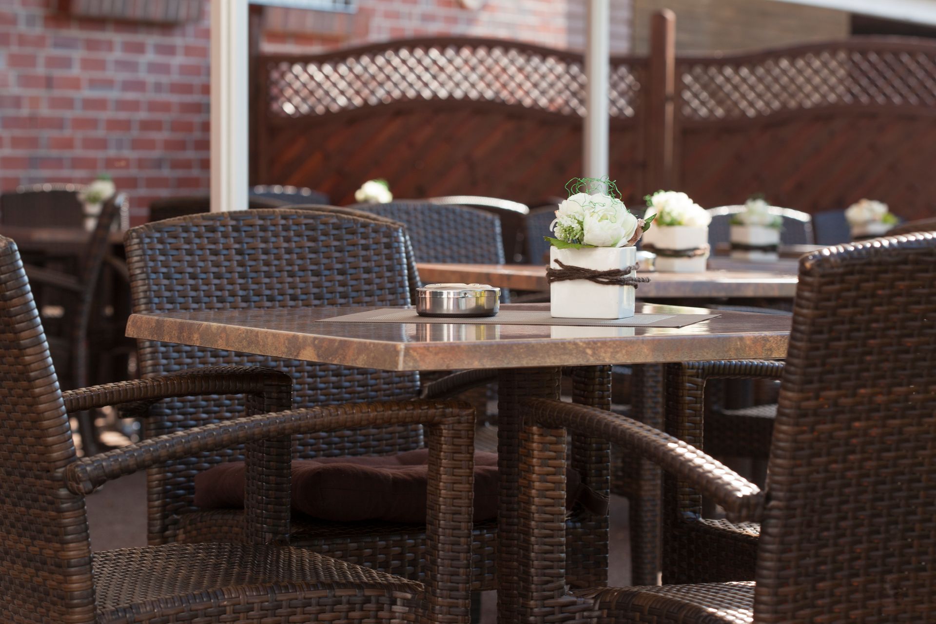 Ein Restaurant mit Korbstühlen und Tischen mit Blumen darauf