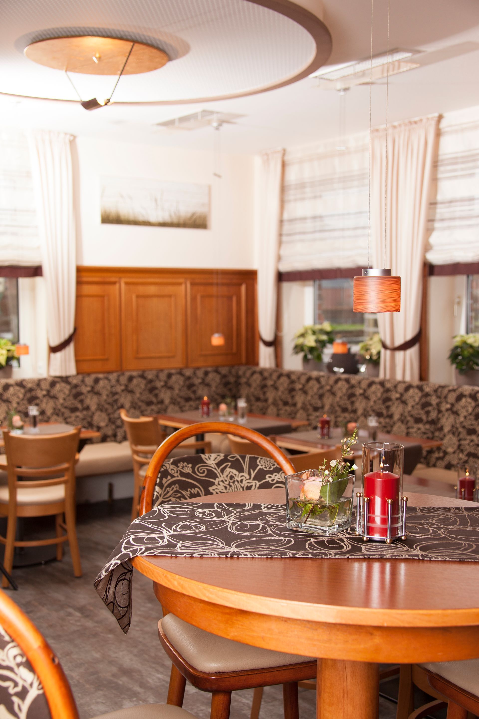 Ein Restaurant mit Tischen und Stühlen und einer Kerze auf dem Tisch.
