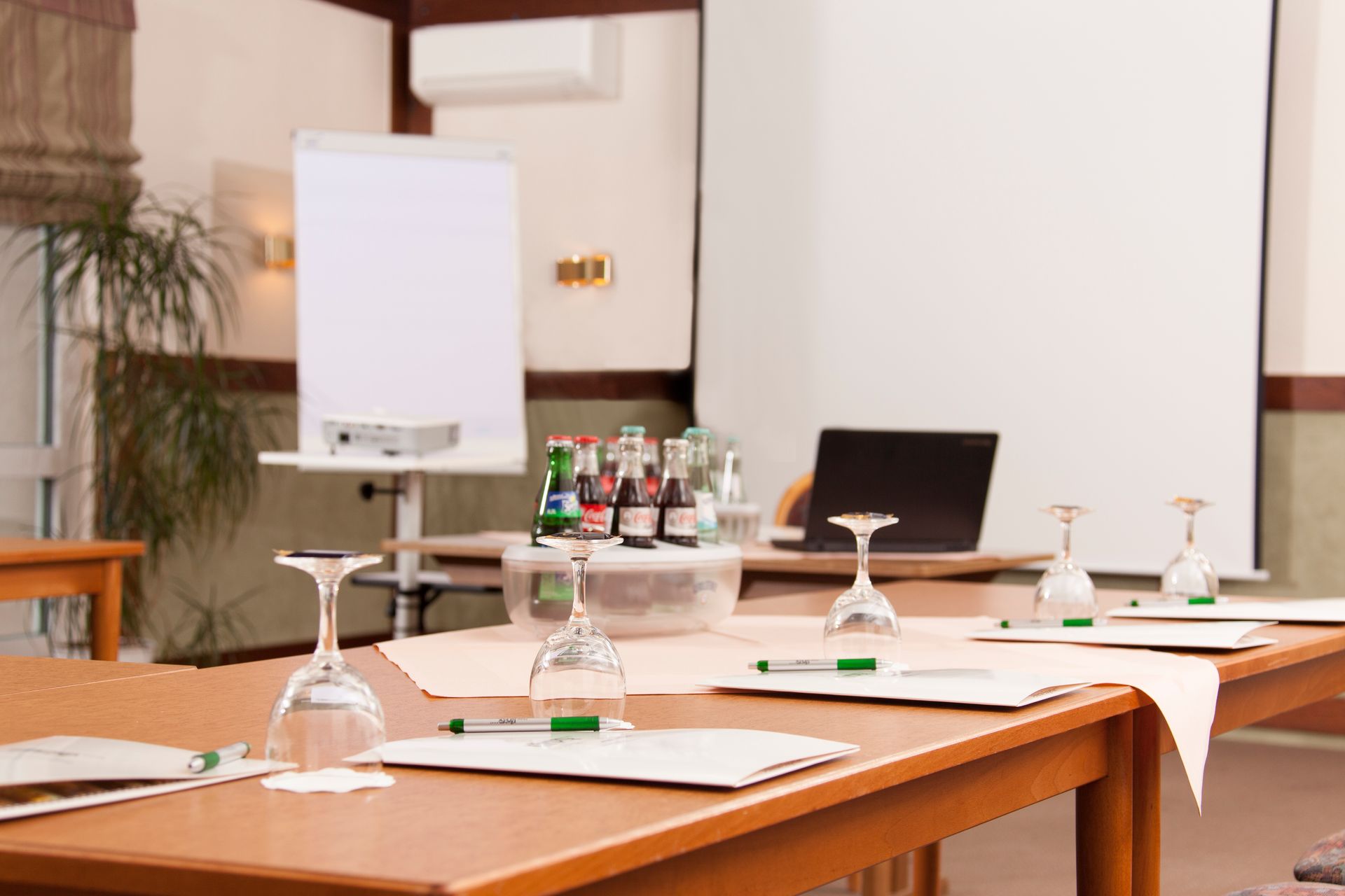 Ein Konferenzraum mit Tischen und Gläsern, der für eine Besprechung aufgestellt ist.