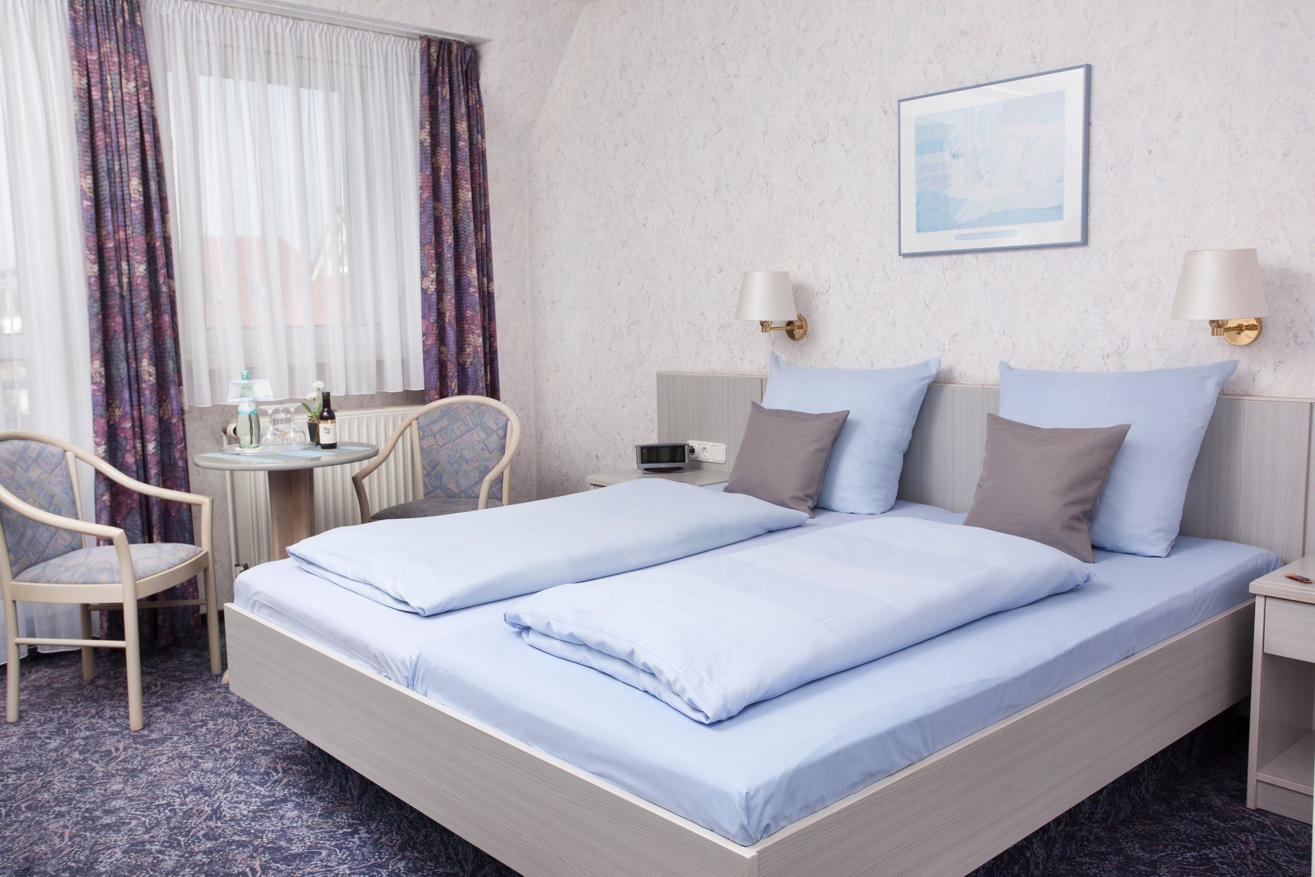 Ein Hotelzimmer mit zwei Betten, einem Tisch und Stühlen