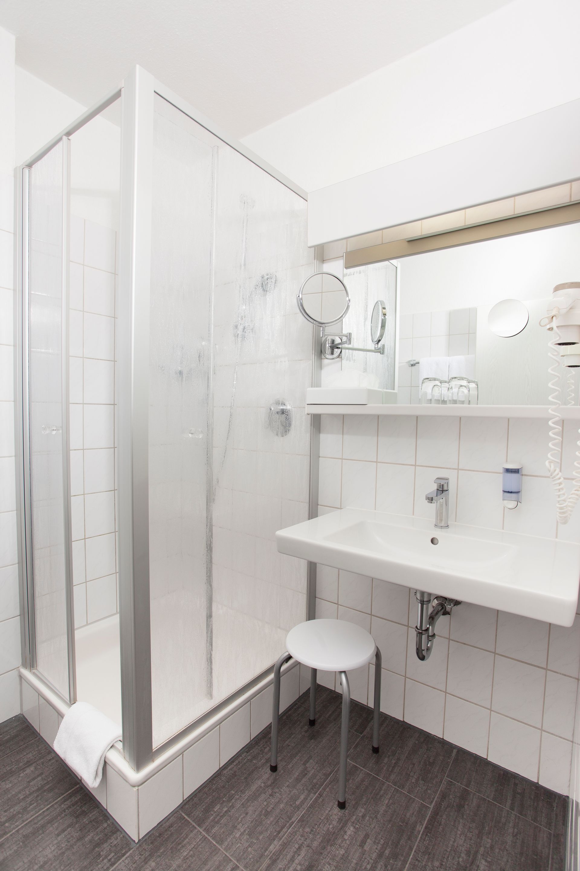 Ein Badezimmer mit Waschbecken, Dusche und Spiegel.