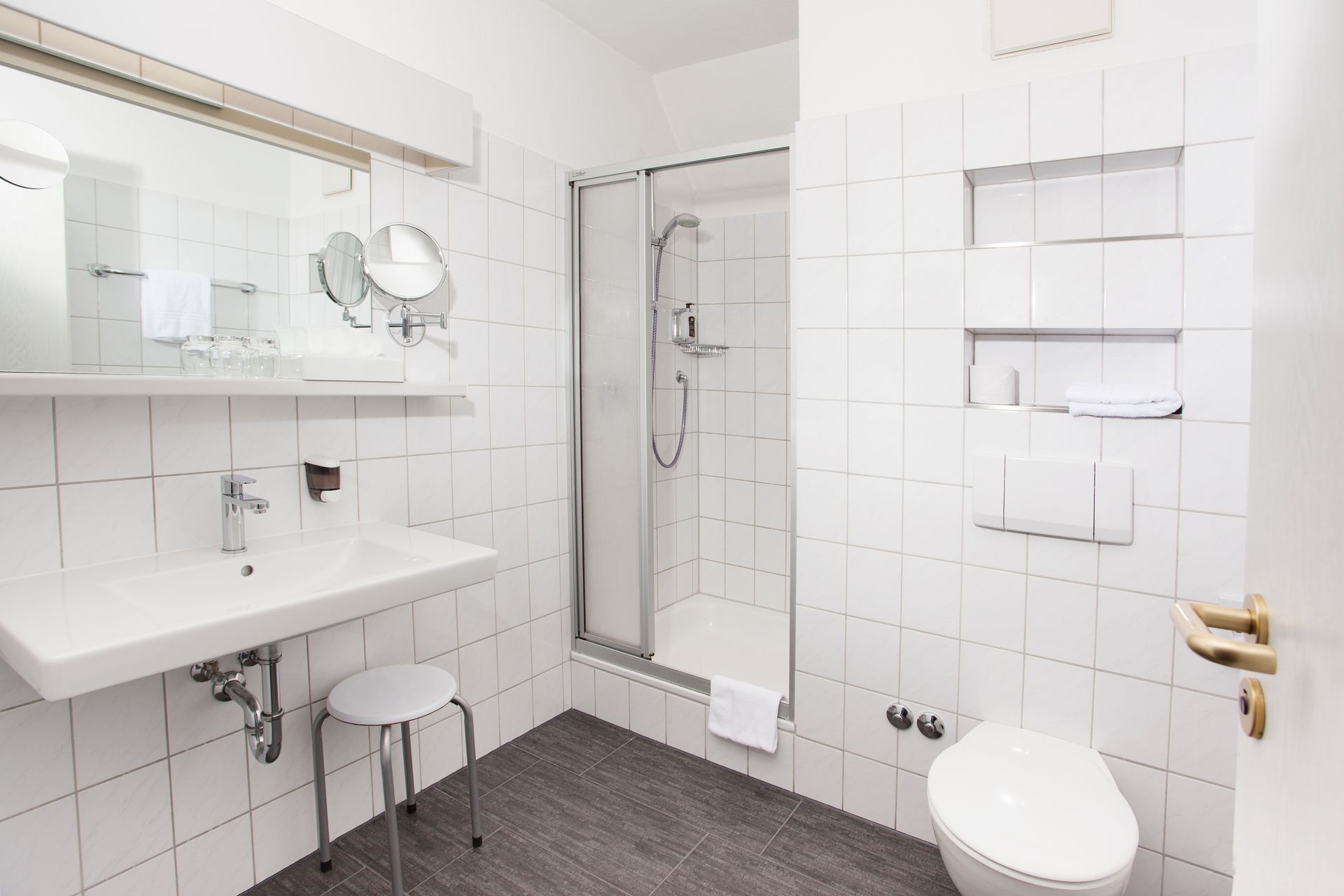 Ein Badezimmer mit Toilette, Waschbecken, Spiegel und Dusche.