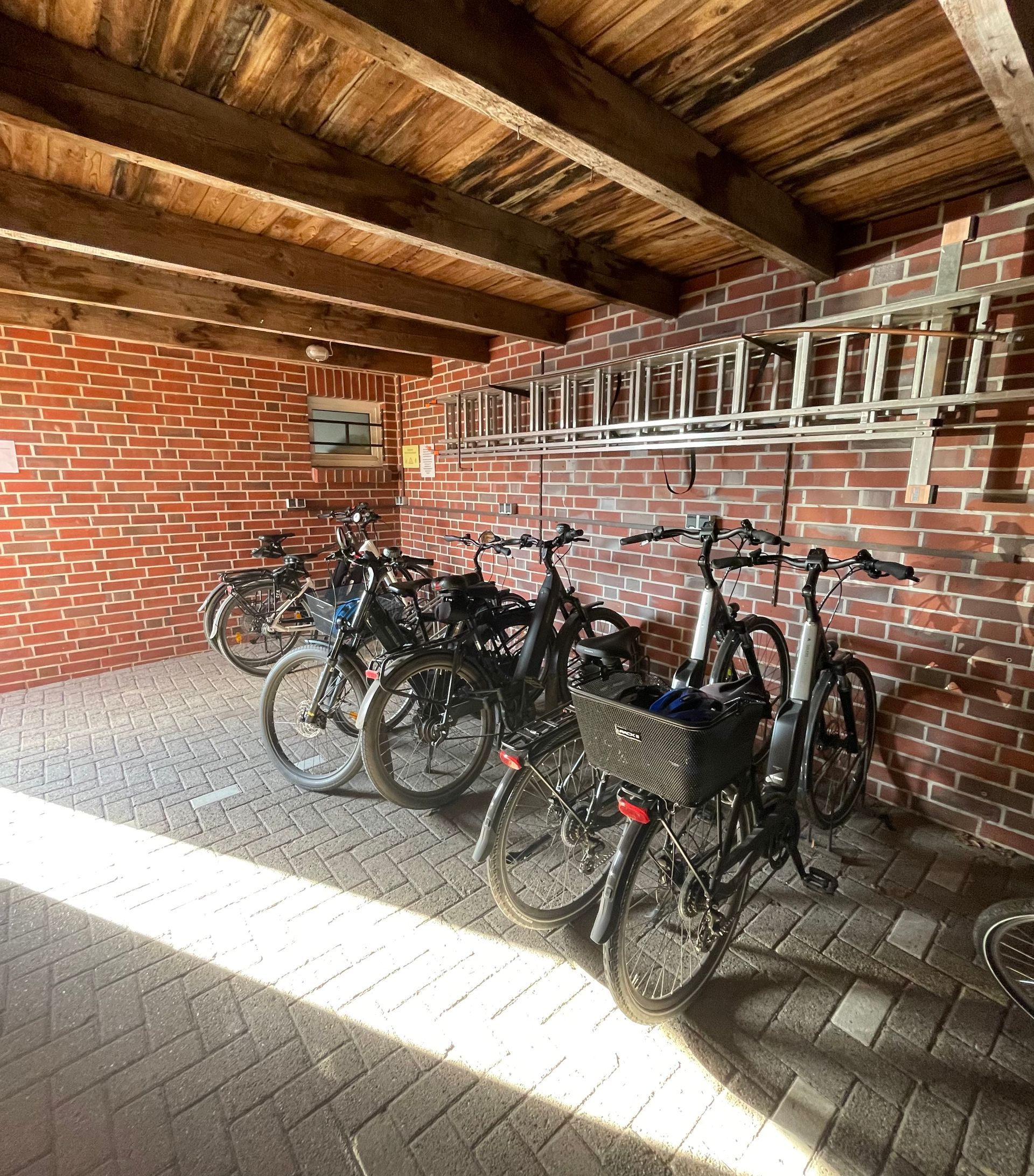 In einer gemauerten Garage ist eine Reihe Fahrräder abgestellt.