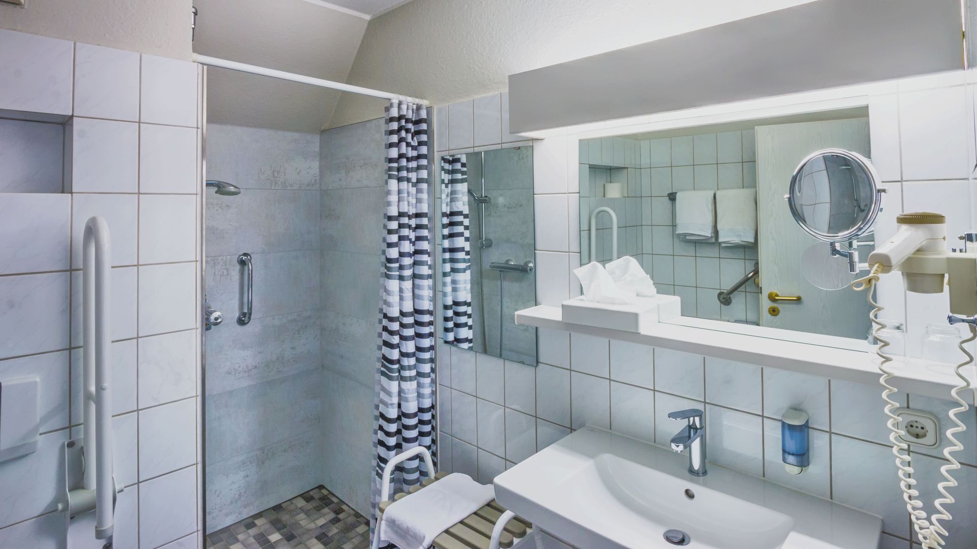 Ein Badezimmer mit Waschbecken, Spiegel und Dusche.