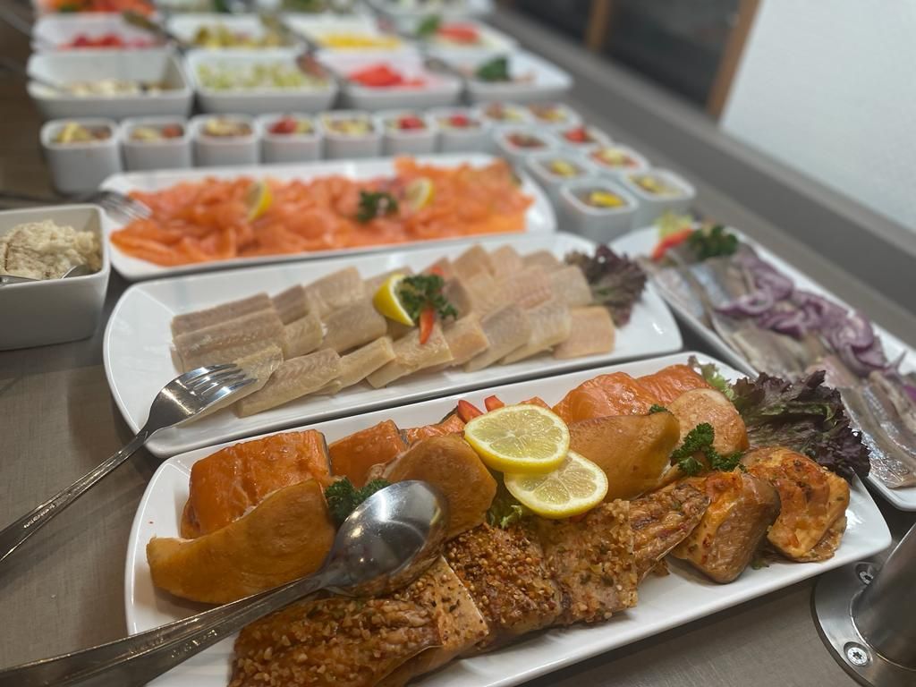 Es kommen viele unterschiedliche Speisen auf den Tisch.