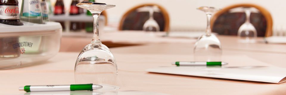 Ein Tisch mit Weingläsern, Stiften und Papieren darauf.