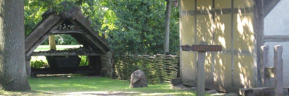 Gras vor einem Holzgebäude.