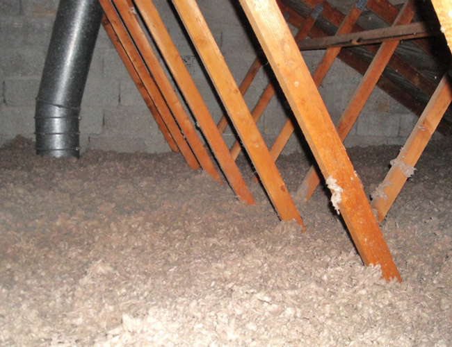 Combles isolés avec chevrons en bois orange et conduit métallique