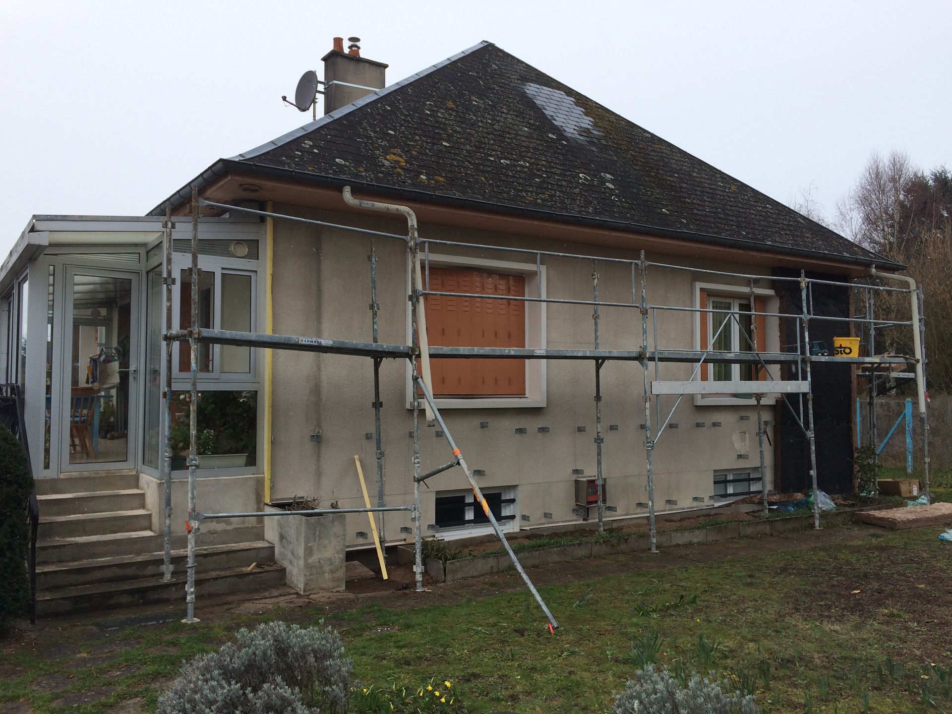 Extérieur de la maison avec échafaudages et travaux de rénovation en cours