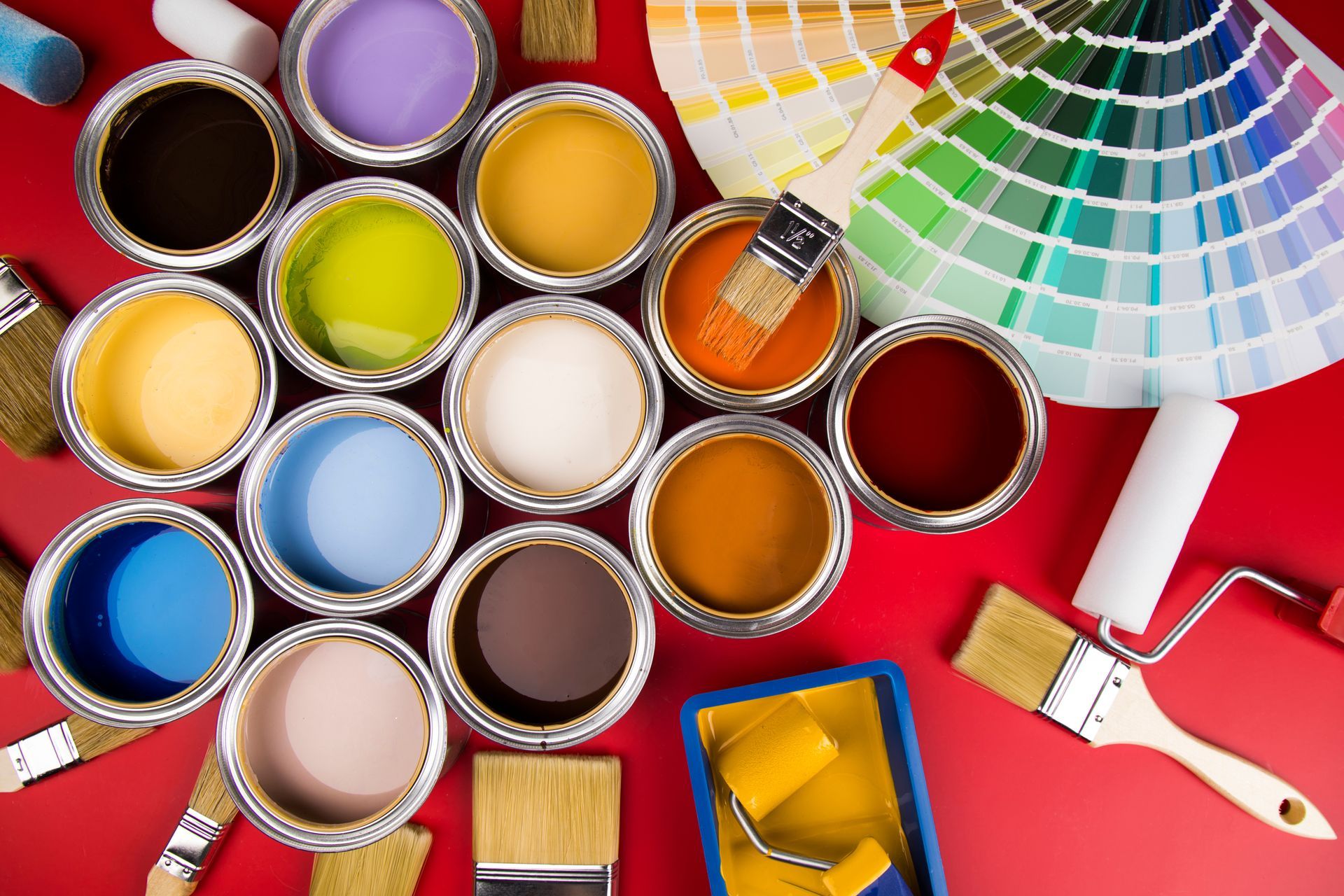 Pots de peinture et pinceaux sur un sol rouge