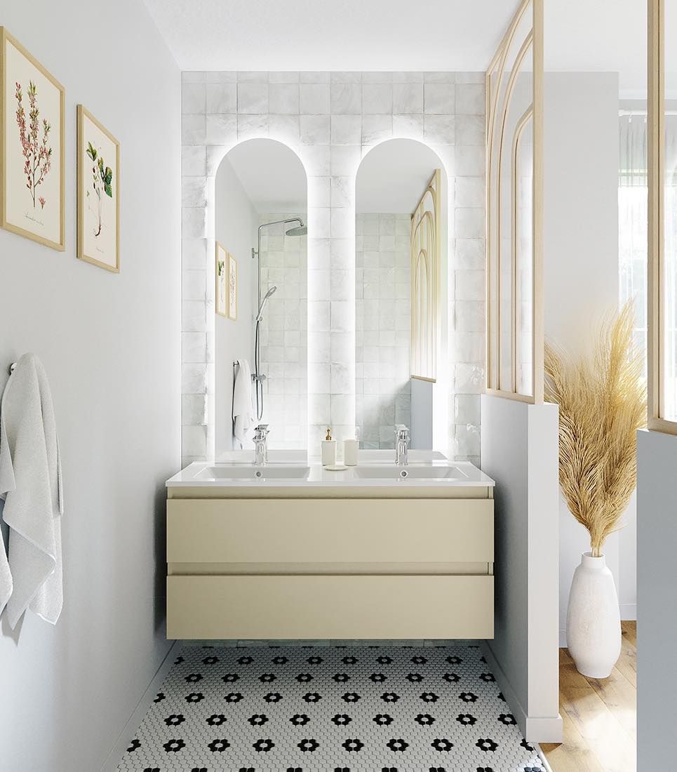 Salle de bains lumineuse avec meuble lavabo crème, miroirs arrondis, carrelage noir et blanc au sol et murs blancs