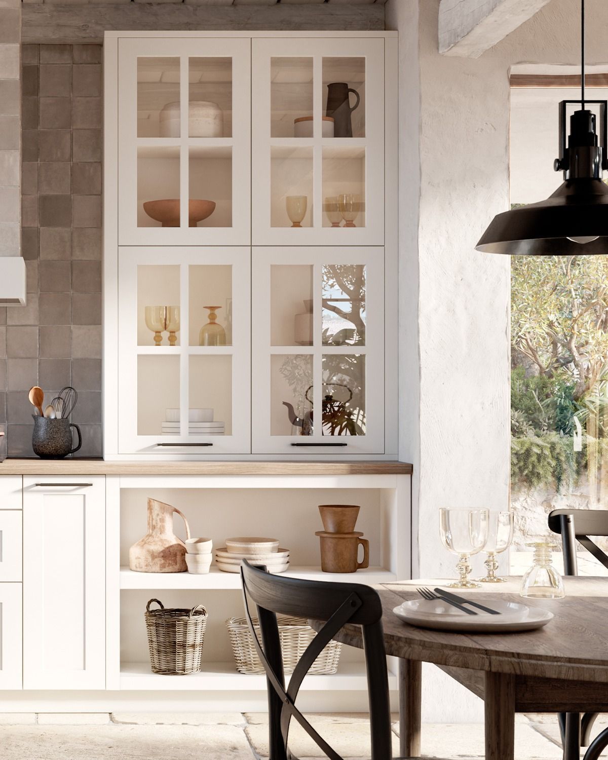 Cuisine lumineuse avec placards blancs, garde-manger vitré et table à manger en bois près d'une fenêtre