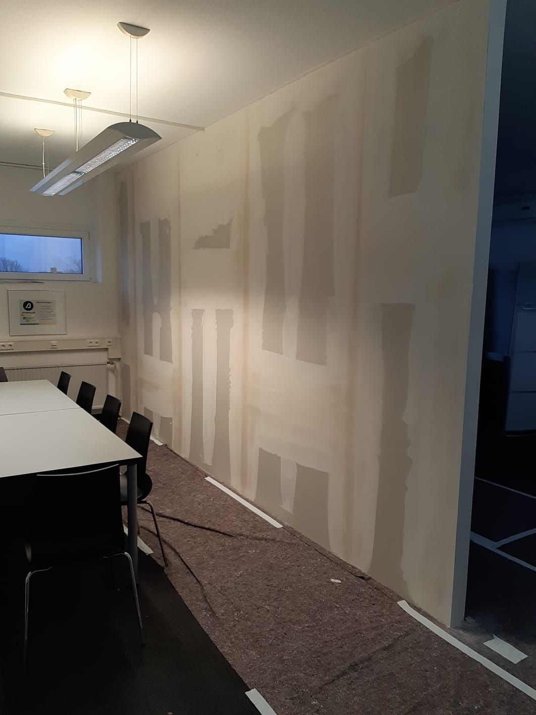 Ein modernes Büro mit grünen Wänden und einem weißen Empfangstresen. BAB Bartovcak Akustikbau