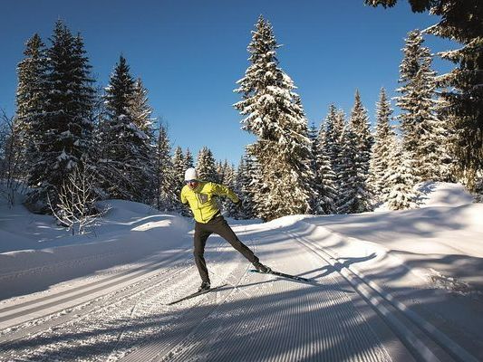 Homme avec une veste jaune faisant du ski