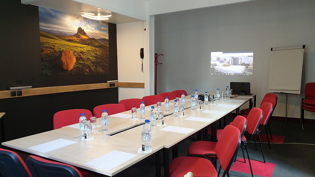 Salle de séminaire avec des chaises rouges et un vidéo projecteur