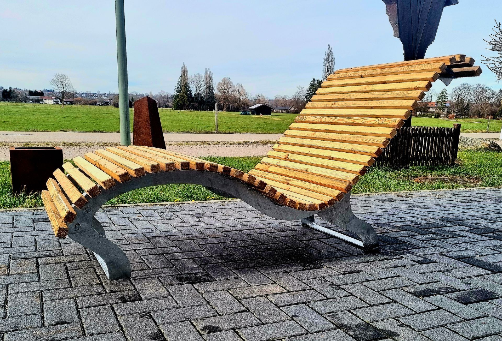 Geschwungene Holzliege mit Stahlunterkonstruktion