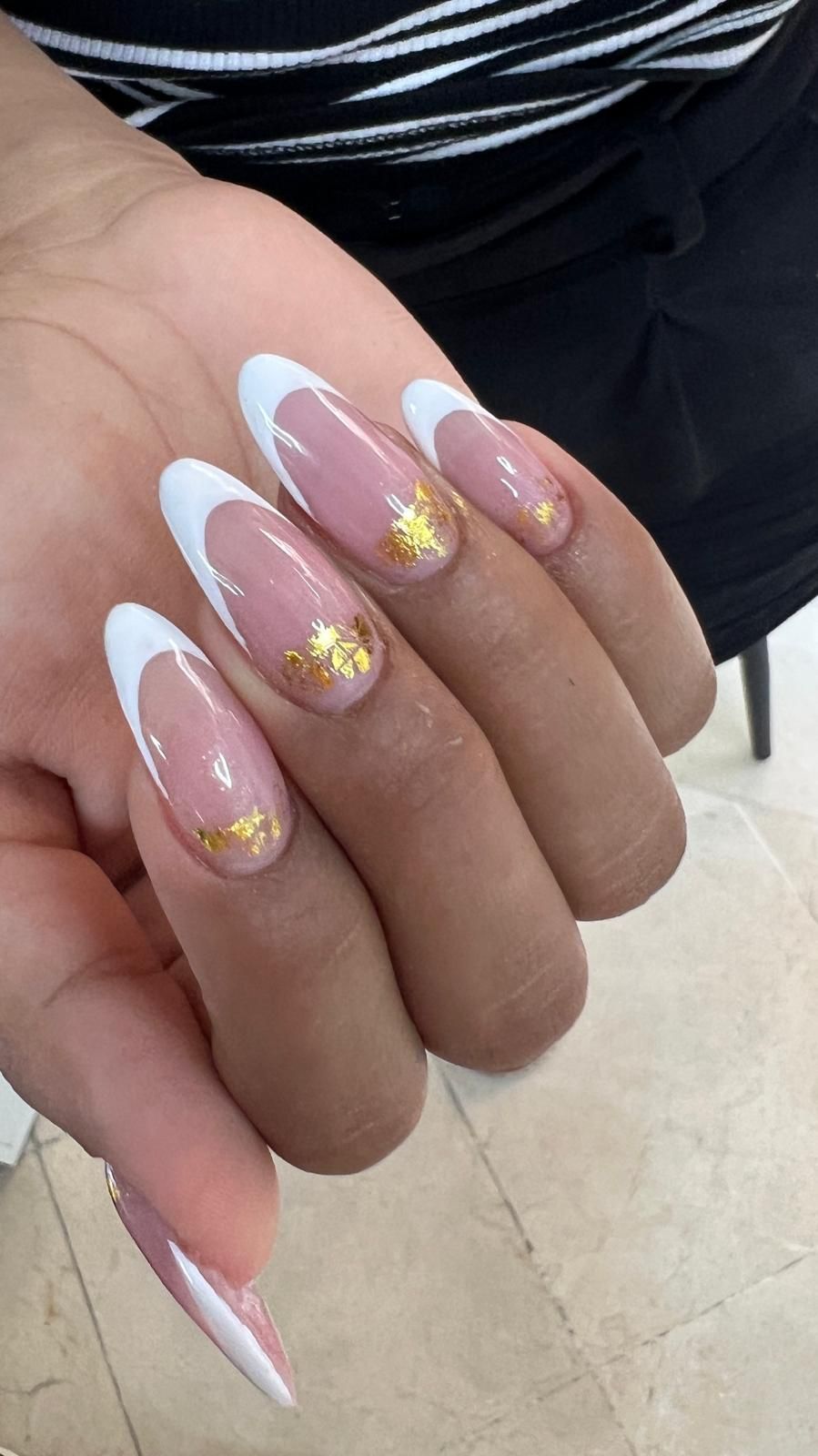 Un primer plano de la mano de una persona con uñas rosas.
